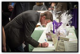 Featured speaker Sean Swarner bids on an auction item
